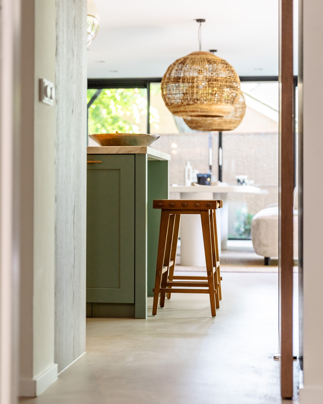 Stijlvoorbeeld gietvloer keuken doorkijk met houten barkruk