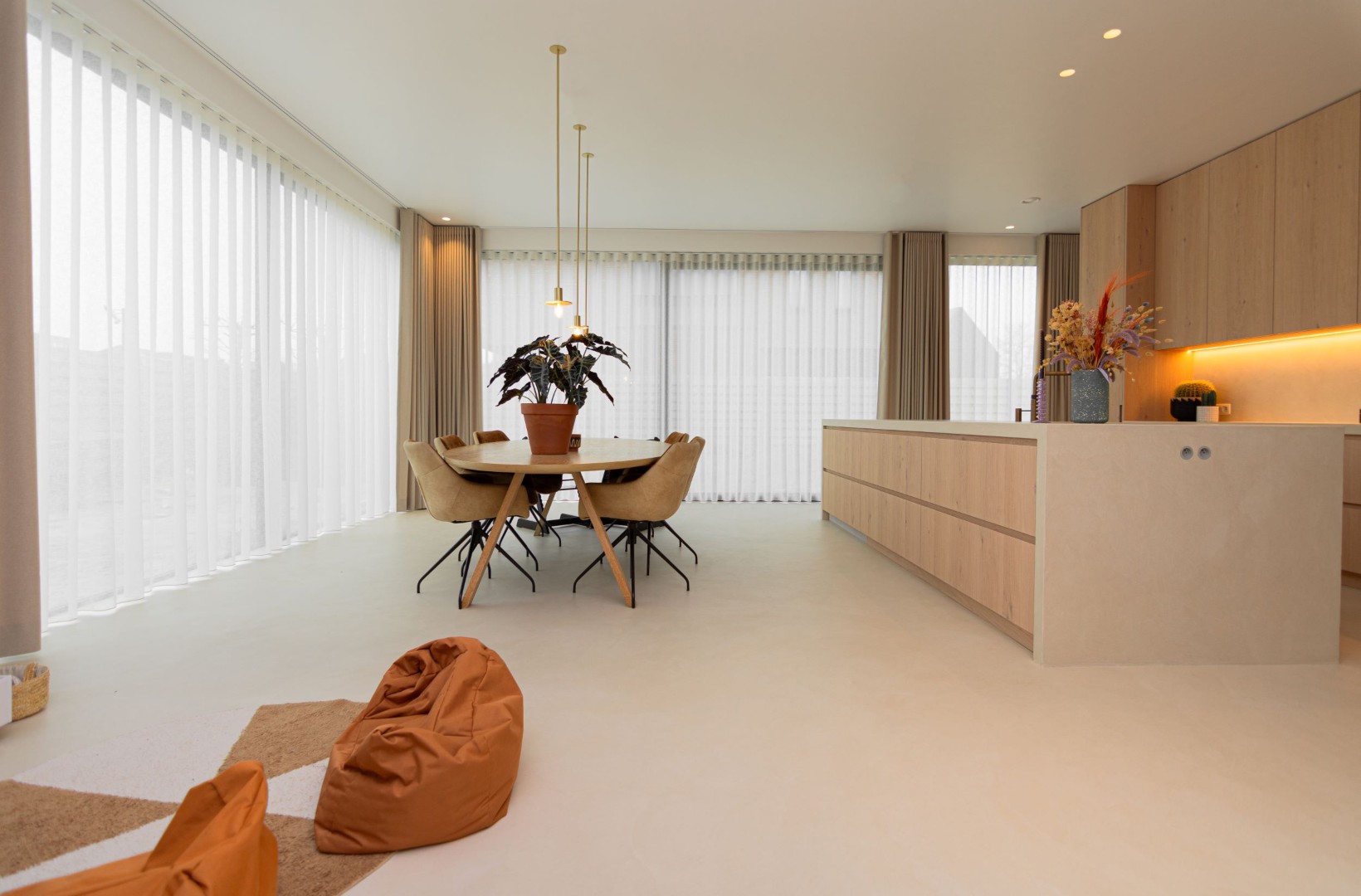 Lichte gietvloer in ruime woon-eetkamer met naadloze afwerking