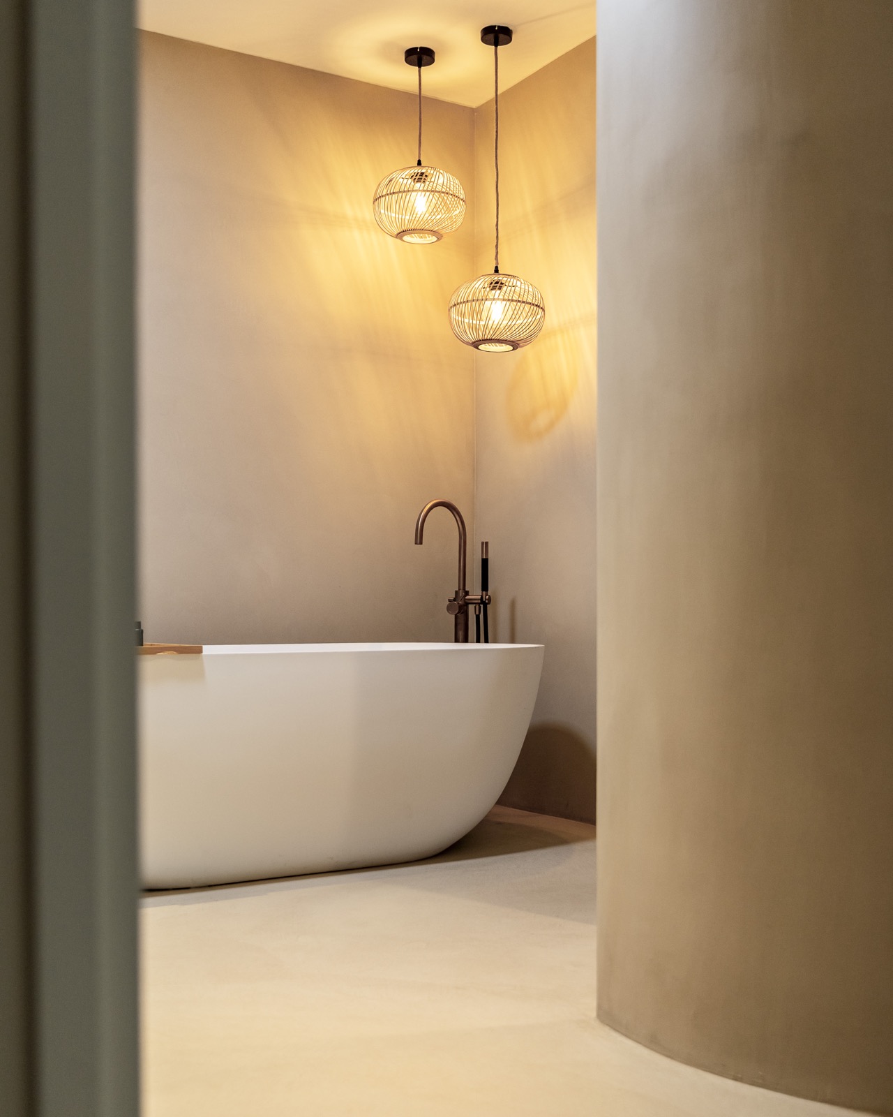 Stijlvoorbeeld microcement badkamer met naadloze wand rond bad