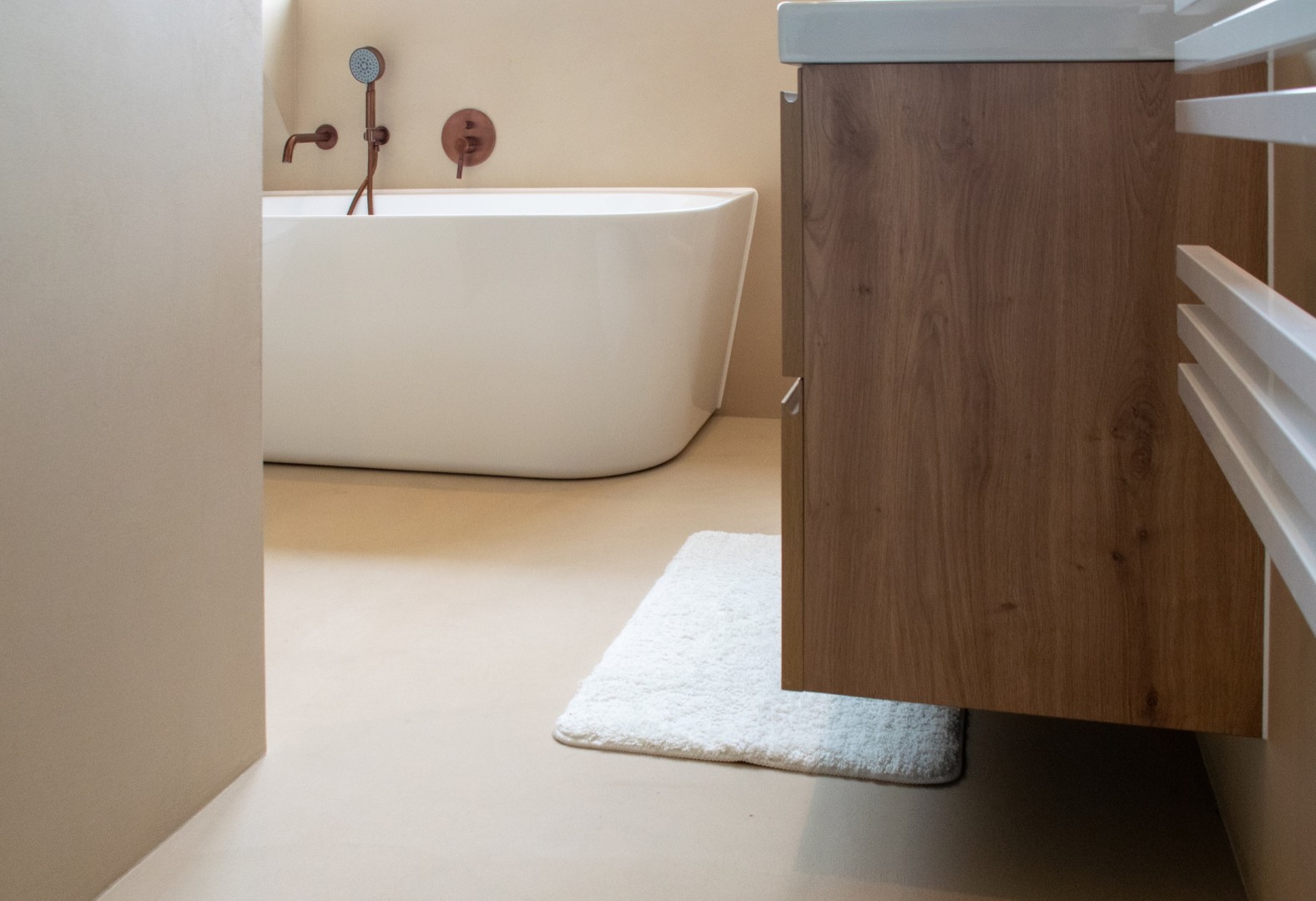 Stijlvoorbeeld microcement badkamer bad wastafelmeubel beige