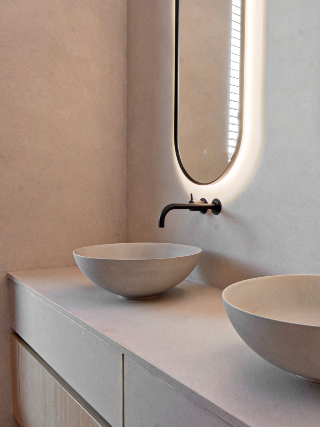 Stijlvoorbeeld microcement dubbele komwastafels met verlichte nis