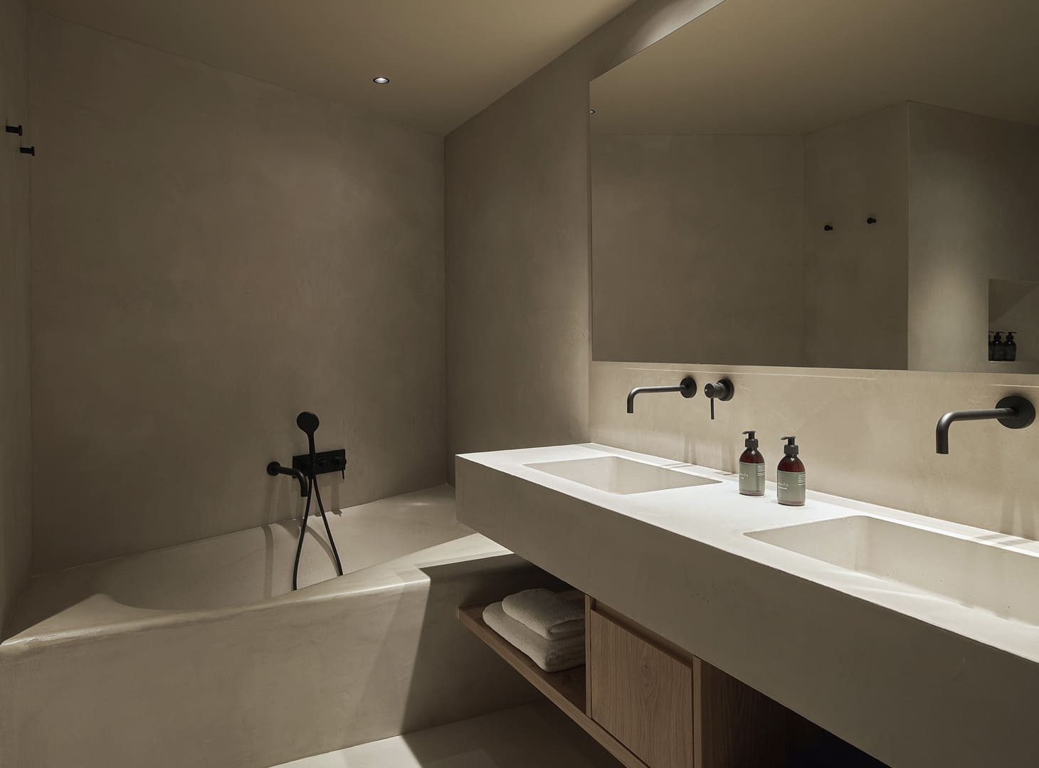 Microcement badkamer naadloos bad en dubbele wastafel in betonlook