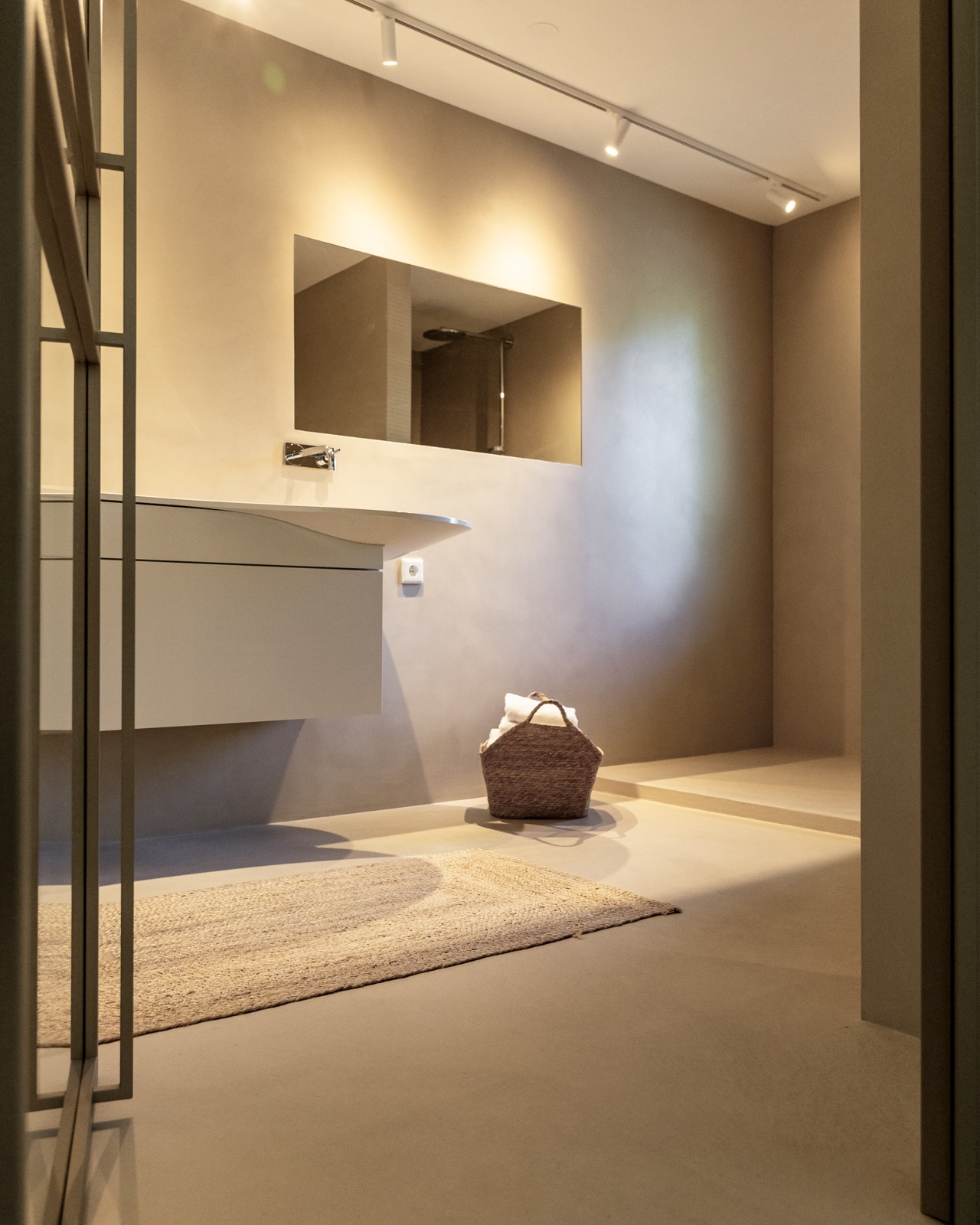 Stijlvoorbeeld microcement badkamer wastafel met doorkijk naar douche