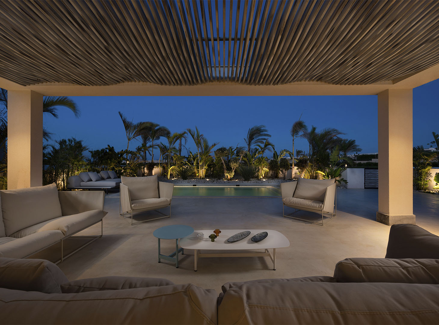 Stijlvoorbeeld microcement buitenterras met pergola in avondsfeer