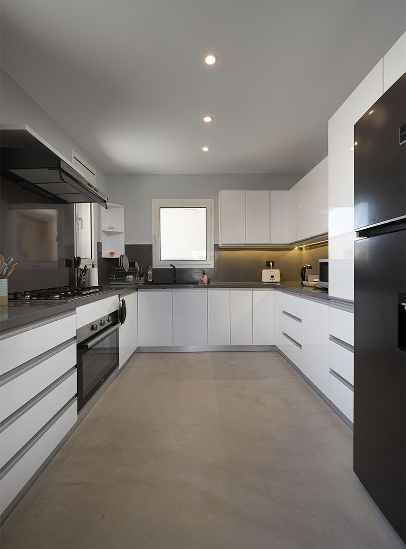 Microcement keukenvloer in witte keuken met betonlook