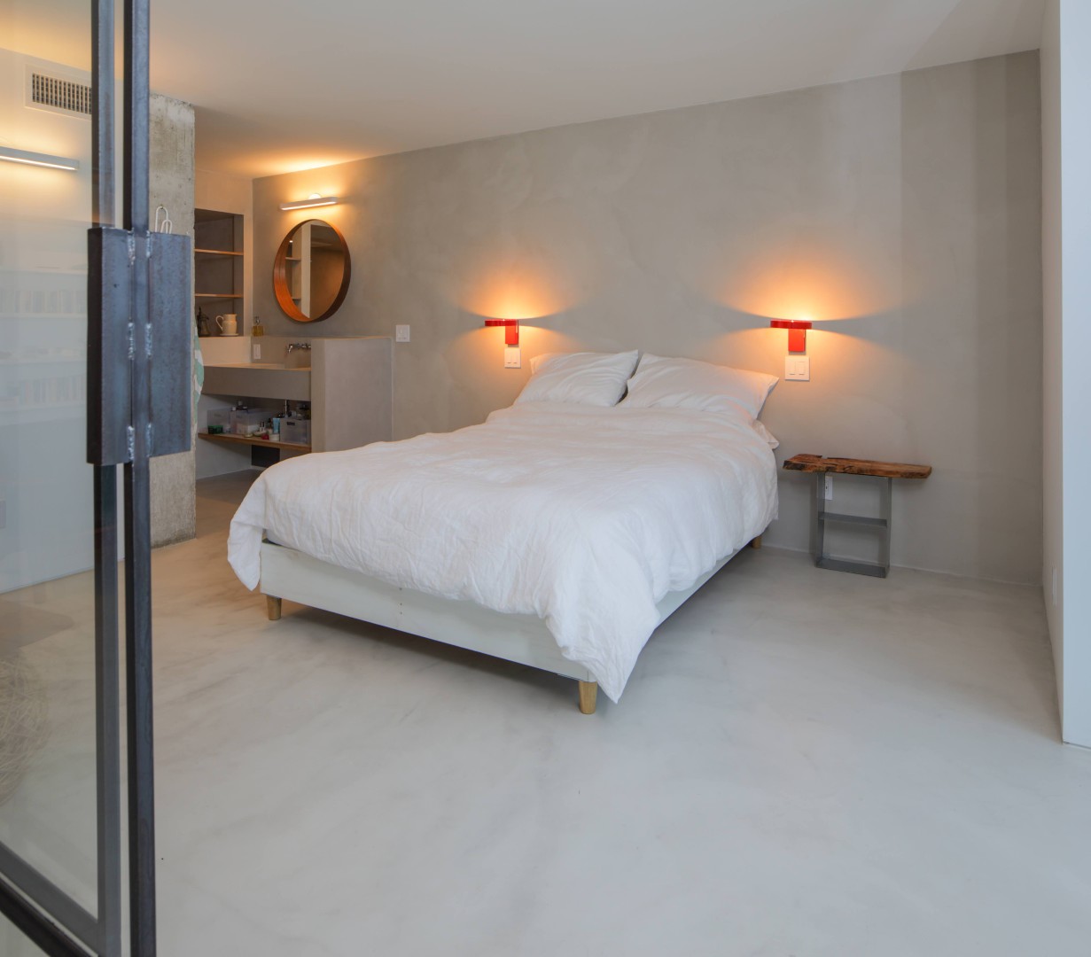 Stijlvoorbeeld microcement slaapkamer met gietvloer en wand