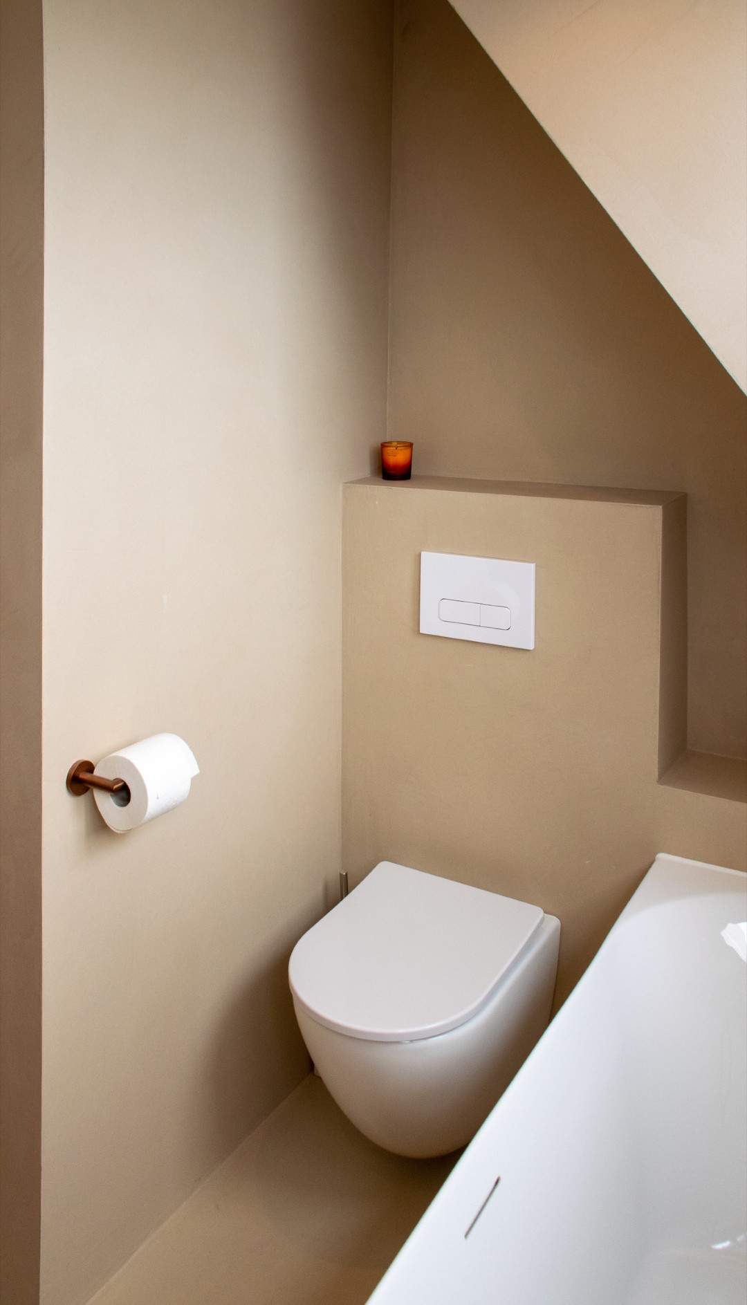 Stijlvoorbeeld naadloos microcement toilet met beige wand