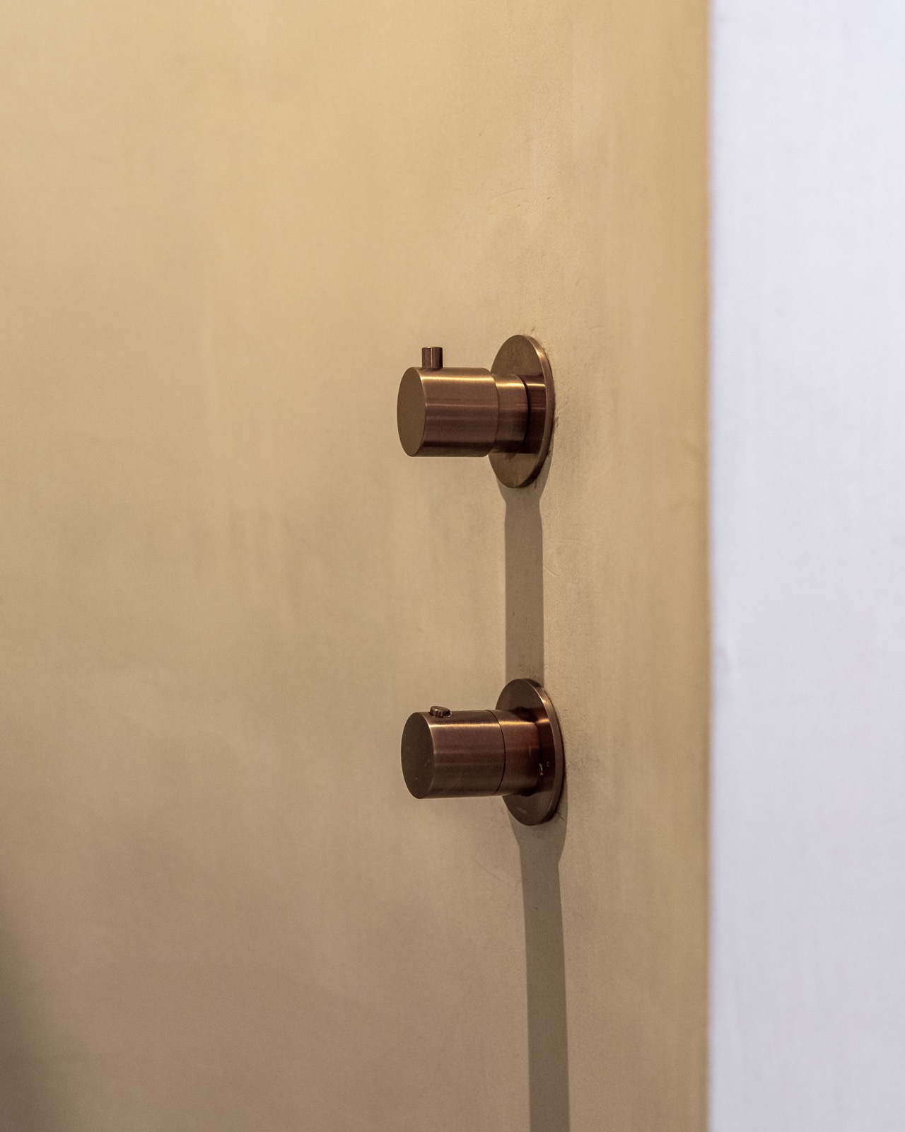 Stijlvoorbeeld microcement wand detail met koperen kraan