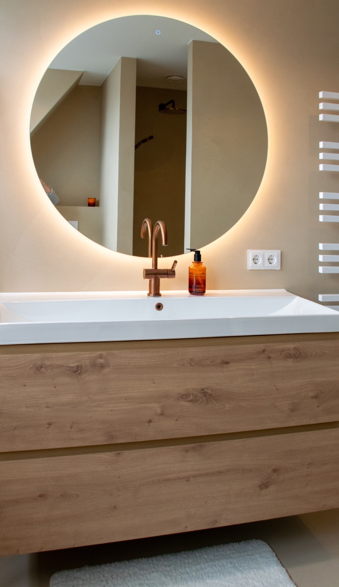 Stijlvoorbeeld microcement wastafel ronde spiegel beige