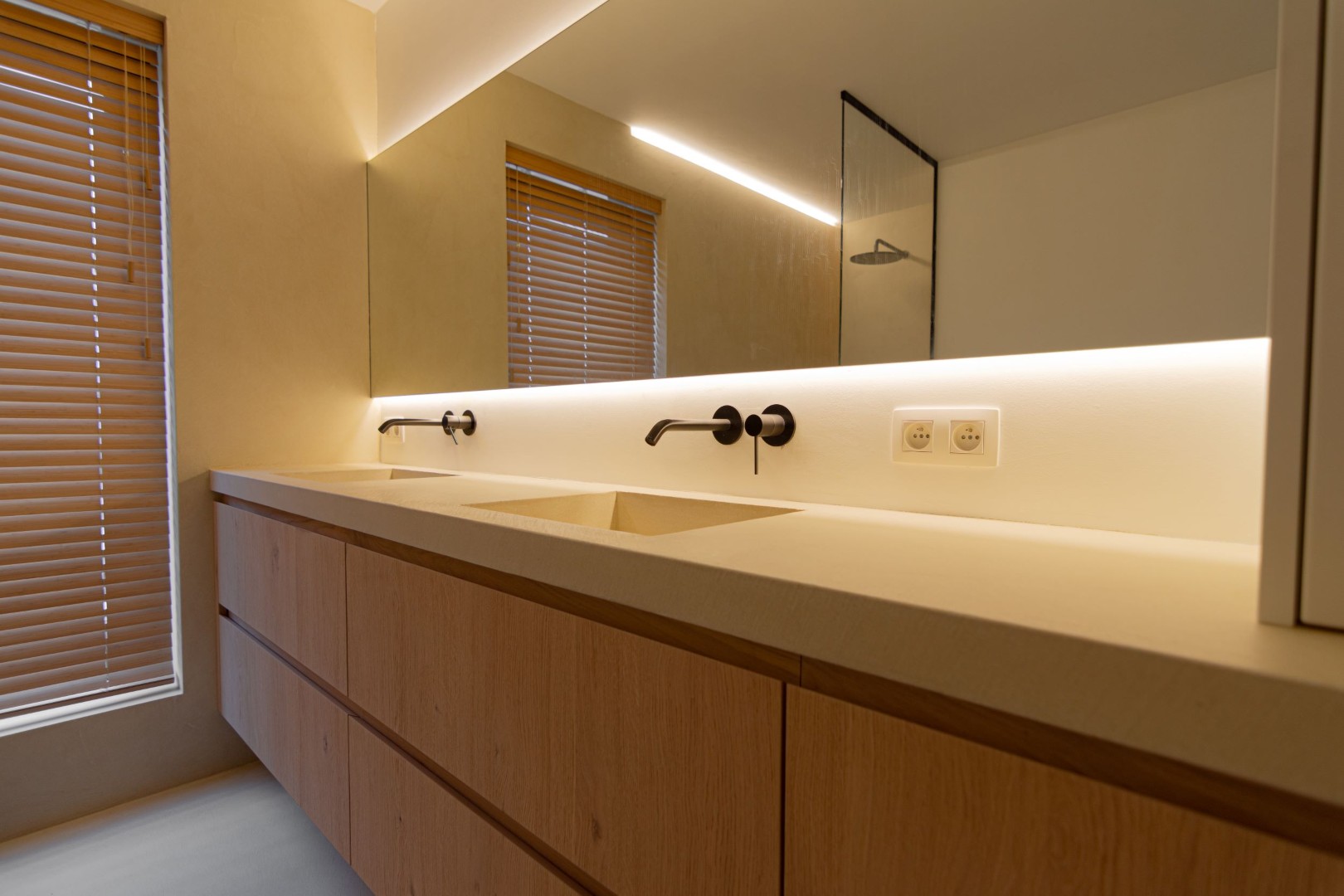 Stijlvoorbeeld dubbele microcement wastafel lang houten meubel